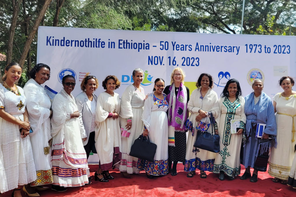 Äthiopische Frauen, darunter die Botschafterin für Frieden Mulu Haile, und die Blogautorin Katrin Weidemann vor einem Plakat zum 50-jährigen Jubiläum der Arbeit der Kindernothilfe in Äthiopien